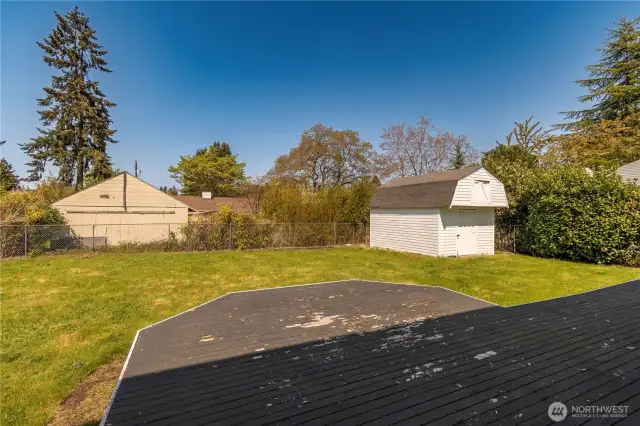 View of back yard, shed and wood deck.