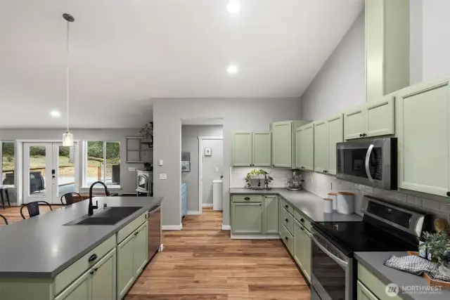Stylish stainless steel and black appliances modernize the space and complement the black hardware throughout the kitchen.