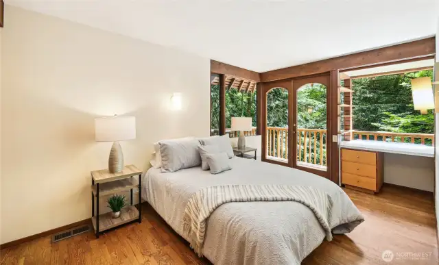 Bedroom 2 on the upper level with built-in desk and access to balcony.