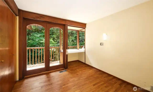 Bedroom 3 on the upper level with built-in desk and access to balcony.