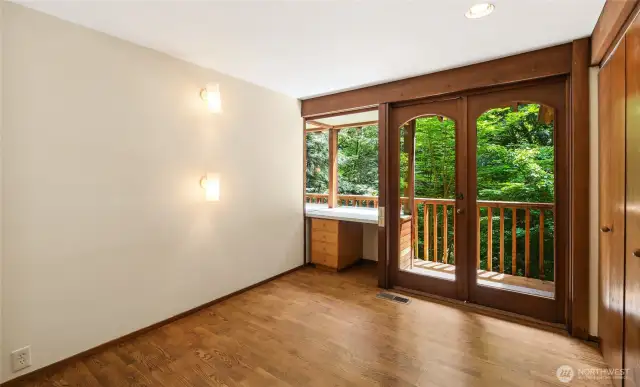 Bedroom 5 on the upper level with built-in desk and access to balcony.