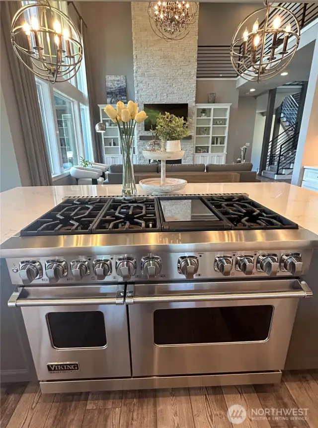 High-end Viking appliances and white quartz countertops. Kitchen looks out to the open two story great room with soaring ceilings and floor to ceiling stone fireplace.   And