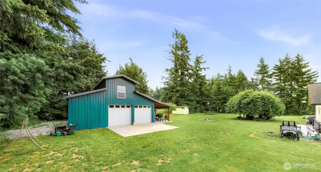 3 bay detached barn-style shop. Metal roof, and paid off solar panels which help with energy costs! Paved area in front of garage doors.