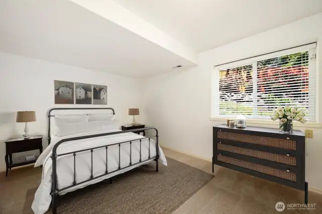 This lower-level third bedroom, virtually staged, offers generous space and versatile living options.