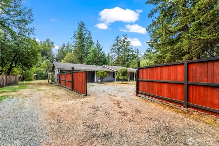 Fenced front entry to home.  Property extends to the left fence and continues back another half+/- acre