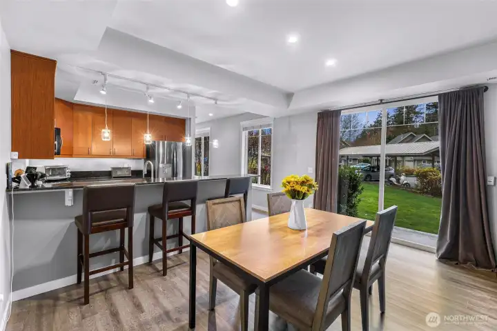 Dining area with oversized windows and a slider that opens to the lawn, filling the space with natural light.