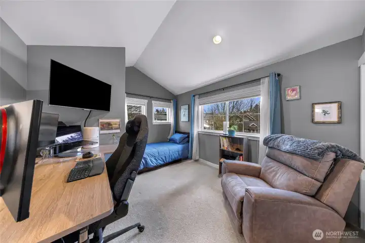 This versatile upper-level room features vaulted ceilings, large windows, and great natural light. The layout offers plenty of space for both a home office and a guest bed, making it an ideal multipurpose area.