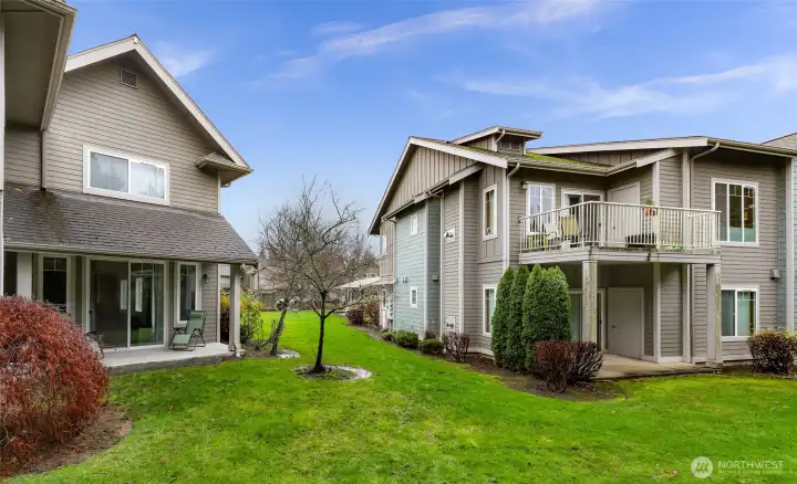 Rear exterior of the home with sliding door access to the patio and open green space maintained by the HOA.