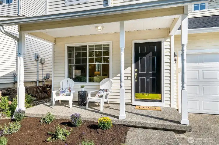 Inviting covered front porch with Adirondack chairs and table is an ideal spot to enjoy your morning coffee or unwind with a good book.