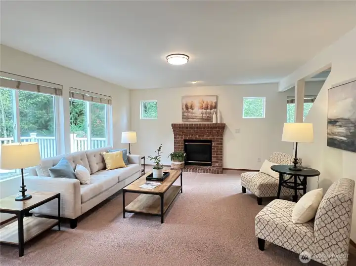 Family room looking straight-on towards the gas fireplace. Notice how wide this room is. Stairs to the upper level are on the right.