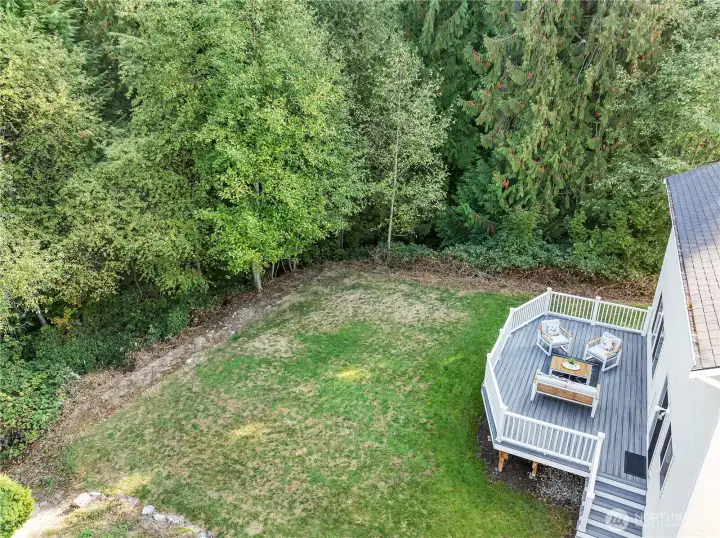 Private backyard featuring a spacious deck, open grassy area, and rare wrap-around greenbelt on two sides, offering exceptional privacy, serene views, and plenty of space to enjoy the outdoors.