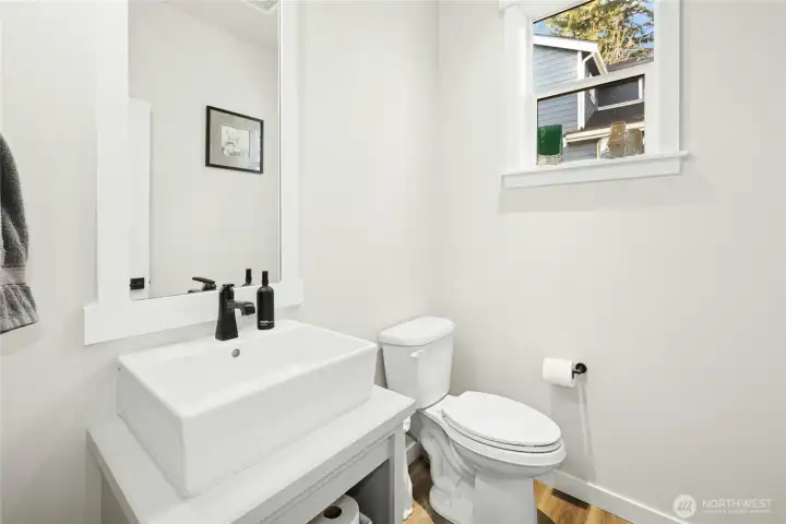 The downstairs bathroom, conveniently located off the office and entry, features a clean, modern design with a stylish vanity, contemporary fixtures, and natural light—ideal for guests or everyday use.