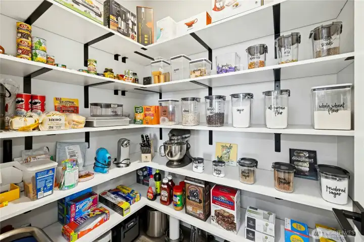 A spacious walk-in pantry offers exceptional storage with custom shelving, keeping everything neatly organized and easily accessible. Designed for convenience and efficiency, this pantry is a dream for home cooks and entertainers alike.