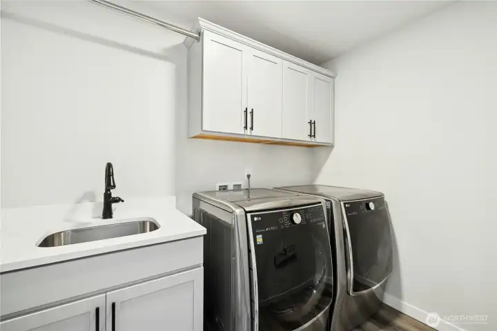 The upstairs laundry room is thoughtfully designed with built-in cabinetry, a utility sink, and plenty of counter space for folding and organization. Located conveniently near the bedrooms, this bright and functional space makes everyday chores easy. Washer and dryer do not convey.