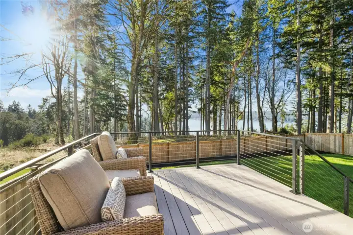 The main-level deck is a true retreat—perfect for morning coffee or evening gatherings—overlooking a lush, tree-lined backdrop with filtered water views beyond. Designed for easy entertaining and everyday relaxation, this spacious deck extends your living space outdoors and offers a peaceful, private setting surrounded by nature.