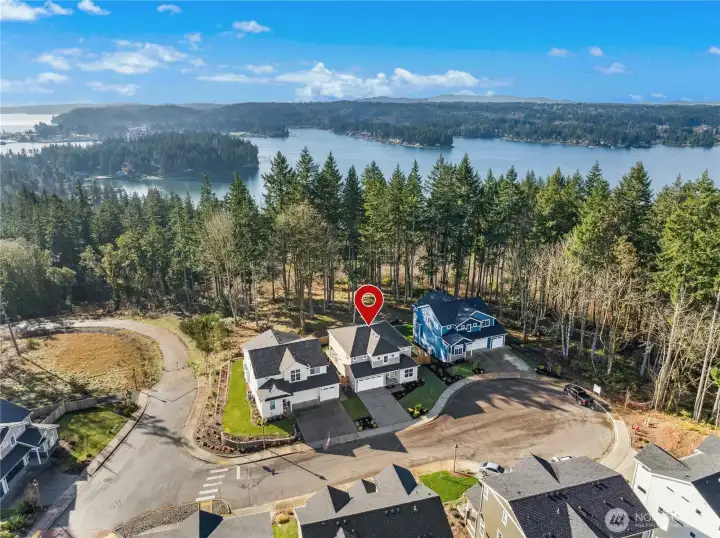 This aerial view captures the home’s exceptional location—set at the end of a quiet cul-de-sac with sweeping views of the water beyond. The pin highlights a rare combination of privacy and scenery, where natural surroundings frame the neighborhood and create a true Pacific Northwest setting. Just moments from trails and shoreline, this is a home that feels connected to nature while remaining close to everything you need.