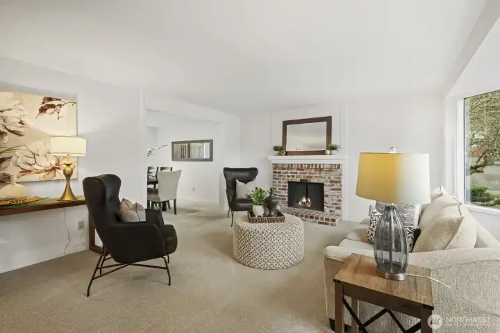 Large formal living room with new carpet, fresh paint, view windows, wood burning fireplace, and lots of charm.