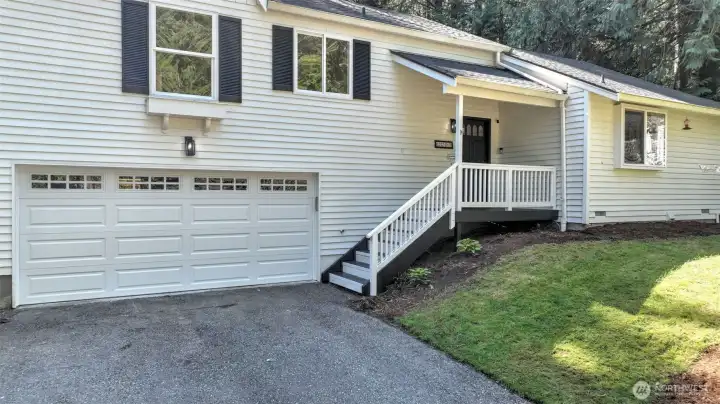 Features a new garage door with quiet belt drive and a charming covered front porch.