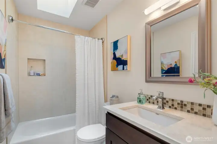 Full bath with skylights and storage in a timeless & neutral design.
