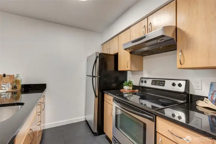 Open kitchen with plenty of cabinets. Granite counters.