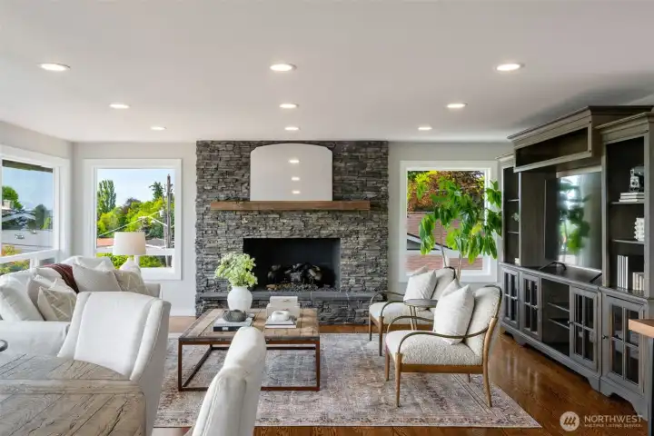 Large living room with stately gas fireplace and wood floors throughout. Large living room with stately gas fireplace and wood floors throughout.