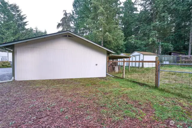 side of detached shop. great for additional parking. Detached storage sheds in the distance.