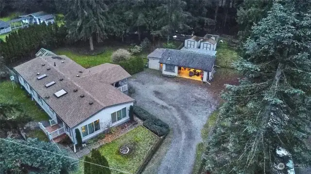 Aerial view of home, shop and 2 storage sheds.