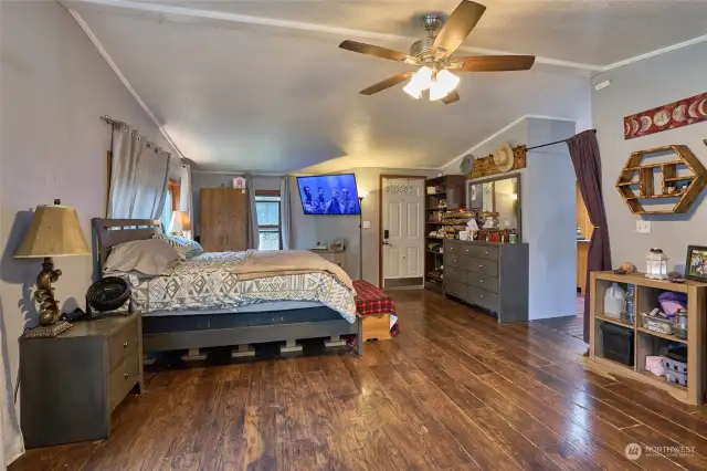 Extra large family room with ceiling fan and laminate wood floors.