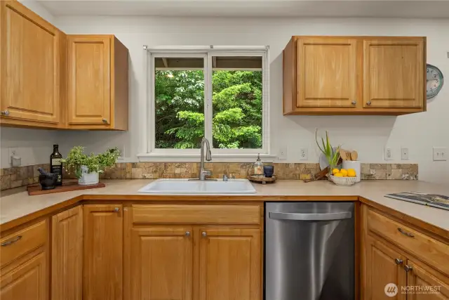 Solid wood cabinets and large sink that overlooks the backyard.