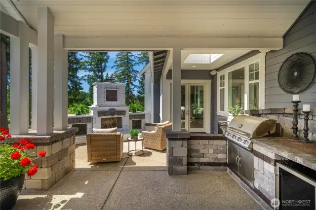 Expansive back of house outdoor space with kitchen.