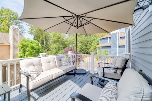 Located just off the main floor kitchen and informal living room, this elevated deck offers a refined, comfortable space for outdoor lounging and entertaining, with top-end decking and peaceful green surroundings