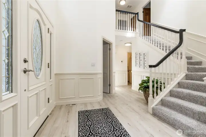 Grand 2-story entry with elegant wainscoting and 2-year old LVP flooring