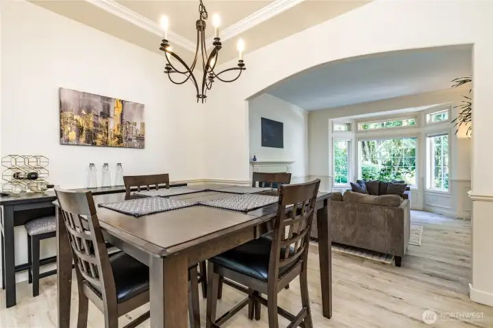 Formal dining room features a tray ceiling and arched doorways. To the left you'll find the French doors leading out to the sunroom!