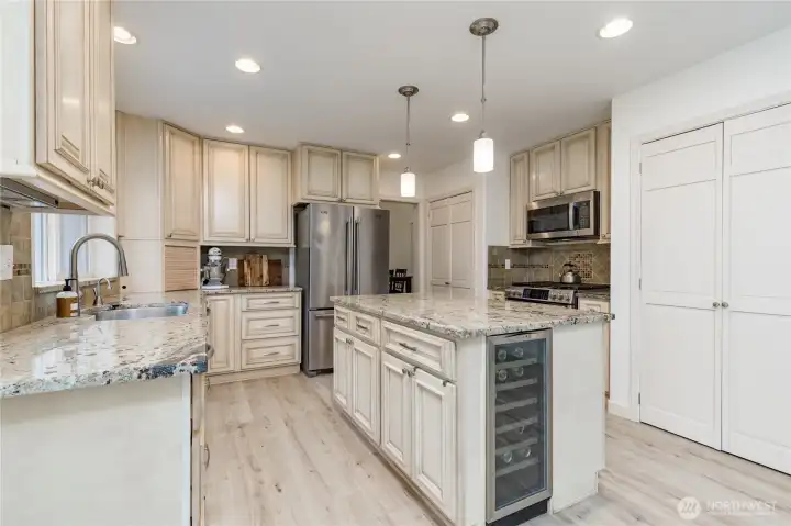 Well-appointed kitchen features granite counters, tiled backsplash, appliance garage and stainless steel appliances including a beverage fridge and a trash compactor!