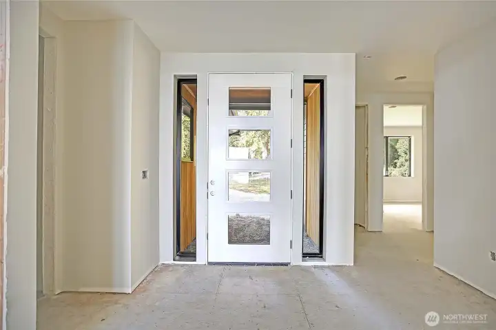 The entry welcomes you with a modern door front framed by glass panels creating a bright and inviting first impression.