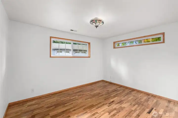 Primary suite with gleaming hardwood floors, perfect for restful nights, relaxation, and stylish living