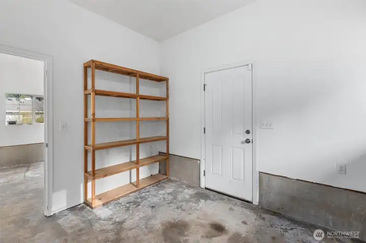 Spacious garage featuring extra built-in shelving, perfect for tools, seasonal items and efficient home organization