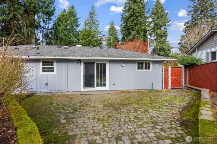 Spacious stone back patio perfect for hosting gatherings, outdoor dining, and entertaining