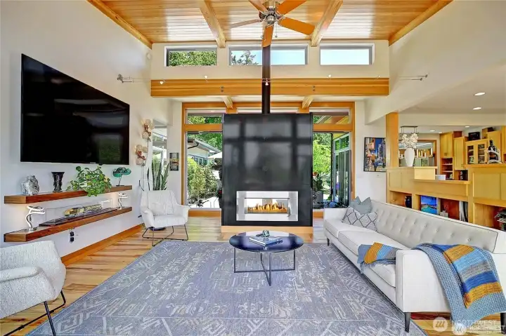 Living room looking toward the entry. Steel double sided gas fireplace....