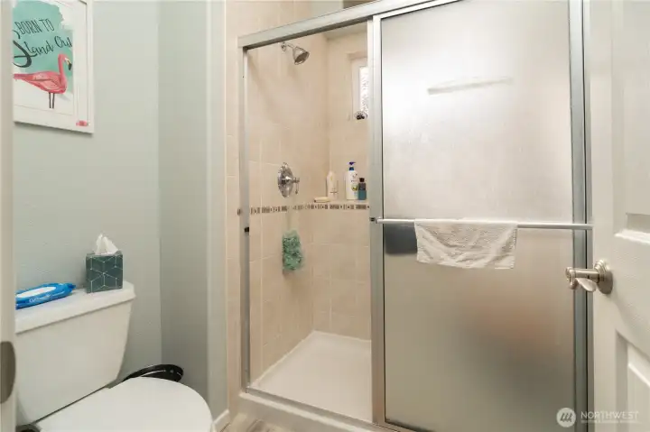 Walk in 3/4 shower with tile surround and shower window blocks for lots of light