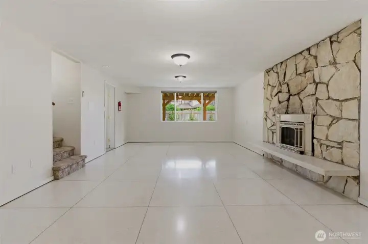 Rec room in the basement features gas fireplace and huge picture window looking out to lovely back yard