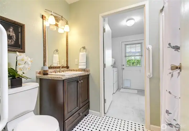 Full bath in hall. Leads to both bedrooms and on this side, utility room. Solar tube over tub/shower adds wonderful light.