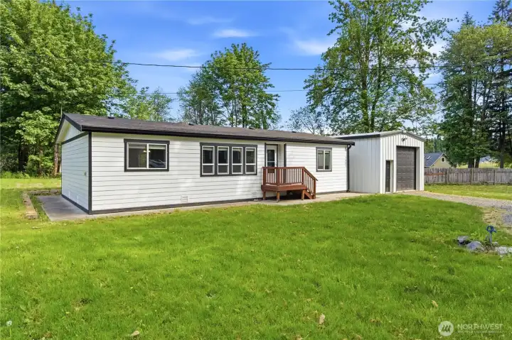 Side view of the front of the home, notice a cement walk way completely around the home! At the bottom right of this photo you will see a hose spigot for quick water access.