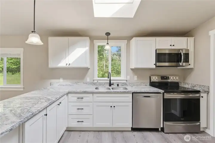 This photo is showing accent drop frosted lighting and a full front view of the kitchen show