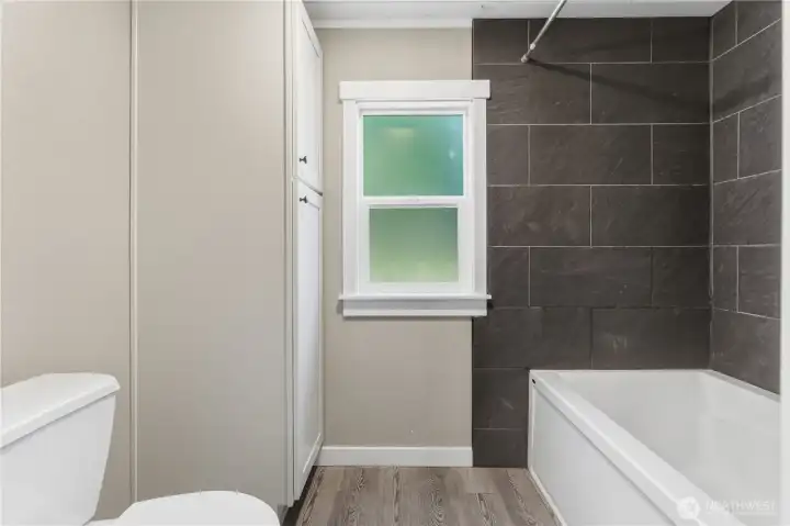 Primary bath, extra large tub/shower area, vented privacy window and storage.