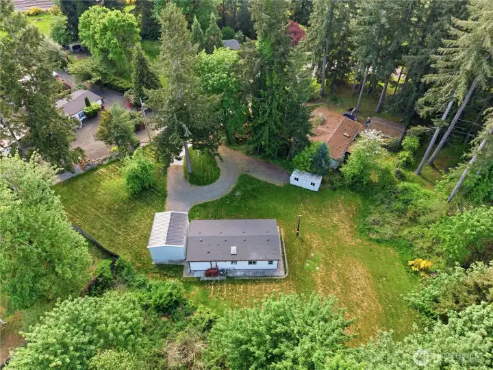 Back aerial highlighting the circular drive way home, shop and Conex