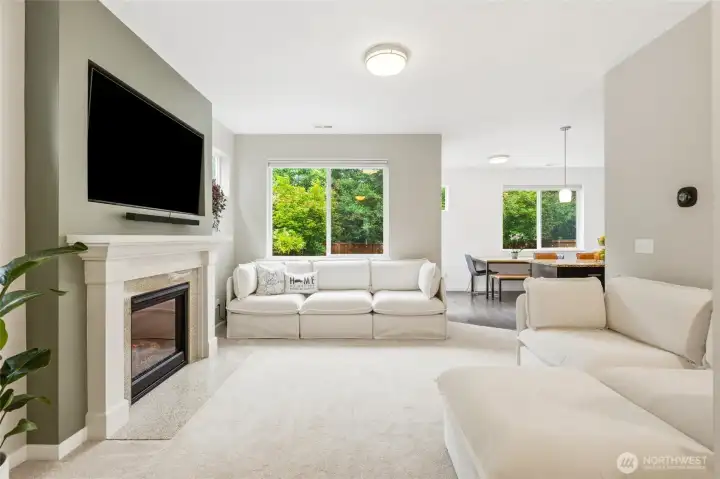 Gather, relax, and unwind in the light-filled living room featuring a cozy gas fireplace and seamless flow into the dining area and kitchen. Gather, relax, and unwind in the light-filled living room featuring a cozy gas fireplace and seamless flow into the dining area and kitchen.