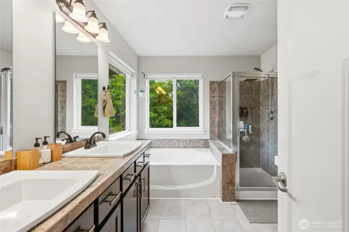 A spa-inspired ensuite features a soaking tub, walk-in shower, dual sinks, and tranquil views of the lush greenbelt. A spa-inspired ensuite features a soaking tub, walk-in shower, dual sinks, and tranquil views of the lush greenbelt.