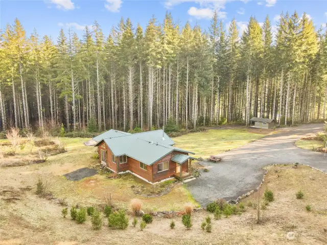 Nestled in privacy with tall fir trees on the property and a garden with flowers, fruits and veggies.