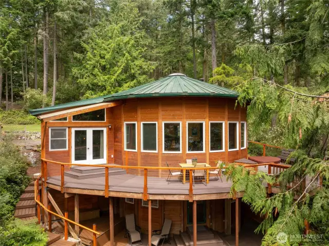 Main house, with living room kitchen area in round, primary bedroom left, lower studio below, seen from east/water side